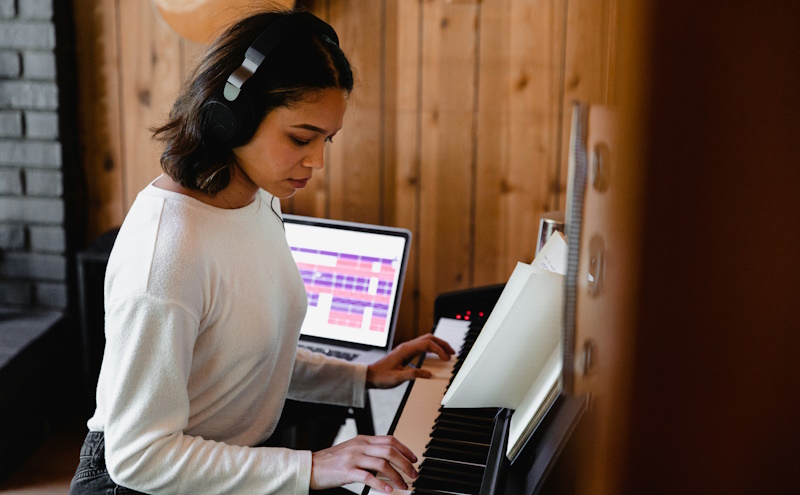 woman playing keyboard with music software in the background