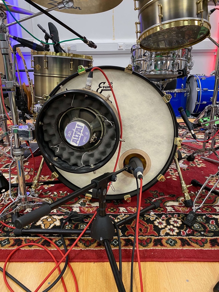 Recording a drum kit with two microphone. Position a dynamic kick drum microphone outside of the resonant head or inside the port hole. You could also use a sub-kick mic to capture the super low frequencies as well.