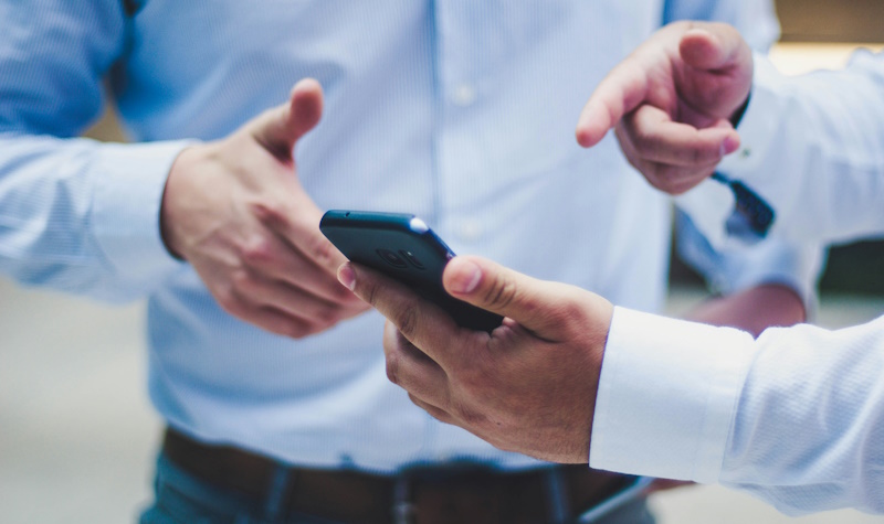 two men looking at a phone